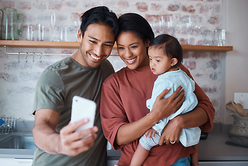 Image showing Happy, parents and baby with down syndrome taking selfie together in kitchen of family home. Happiness, smile and mother and father bonding with disabled child while taking picture on phone in house.