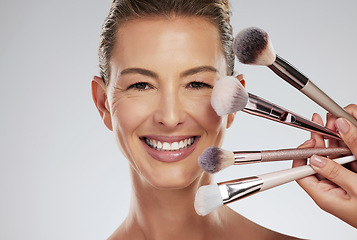 Image showing Makeup, beauty and woman with foundation brushes in studio portrait with facial cosmetics and skincare products. Smile, and happy make up artist or beautician and elegant face model with mockup space