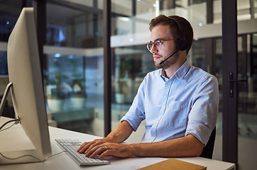 Image showing Call center, web communication and businessman working as consultant as telemarketing company in dark office. Customer service worker consulting on internet during night shift and overtime at startup