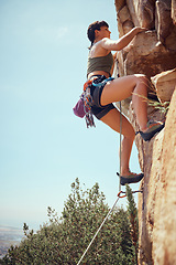 Image showing Mountain, climbing and sport with a sports woman or athlete abseiling outdoor for health and fitness. Training, workout and exercise with a young female athlete or climber scaling a rocky cliff