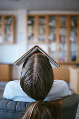 Image showing Burnout, tired and sleeping student with book on face in university library learning, education or reading problem. Fatigue, frustrated or bored college woman and research studying for language exam