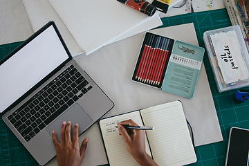 Image showing Hands of black woman artist, planning and art stock taking while writing at desk in notebook with laptop. Professional creative, oil pastel and paint in overhead for painting exhibition.