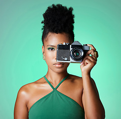 Image showing Black woman, photographer or fashion model on green studio background in creative art, clothes brand or designer social media blog. Portrait, camera and digital photography person with cool hairstyle