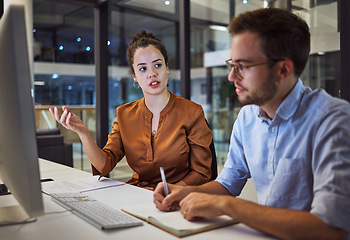 Image showing Business training, team planning and woman planning a corporate strategy on the internet with businessman in a dark office. Business people talking about idea for company partnership during overtime