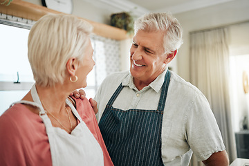 Image showing Senior couple, cooking and home while talking, happy and bonding wearing apron in kitchen at home while talking and planning dinner. Smile of a mature man and woman bonding in their Australia house