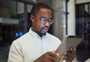 Image showing Tablet research, night planning and businessman working on email on the internet while in a dark office at work. Corporate African employee reading communication online on tech while doing overtime