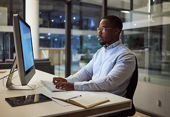 Image showing Businessman typing on computer with internet analytics in an office at night. Professional entrepreneur send email, doing online research, analysis and reading report trying to reach work deadline