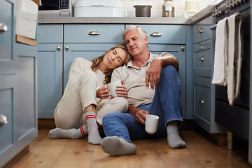 Image showing Senior couple, love and support while sitting together feeling safe, relax and calm drinking coffee and bonding comfortable on a kitchen floor. Happy old man and woman enjoying retirement together