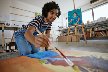 Image showing Studio, art and a woman painting on floor in design school with creativity and paint brush. Artist student from India, happy painter and a girl working on creative school project canvas in classroom.