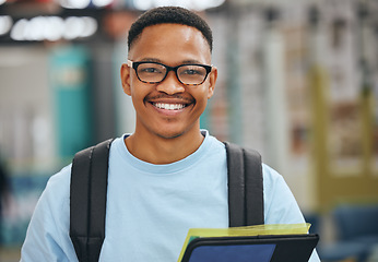 Image showing Black student, education and man with smile in library, college or university with books for homework assignment. Happy African american male with glasses at campus to study, learn and gain knowledge