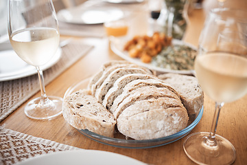 Image showing Sourdough bread, food and lunch meal for fine dining, eating and dinner table in house, restaurant and cafe. Closeup slice of wheat grain baguette, nutrition and artisan rye on plate enjoy with wine