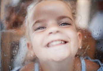 Image showing Happy funny girl, face on window with flat nose on rainy glass and comic portrait at home. Young kid play joke, child alone with big smile and laughing crazy humor closeup in San Francisco winter