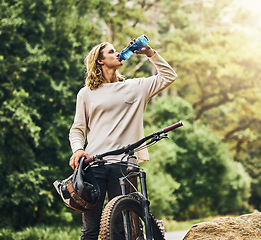 Image showing Mountain bike, drinking water and man from Berlin in nature after a adventure sport workout. Sports, exercise and fitness ride of a healthy person athlete training cardio on a outdoor road by trees