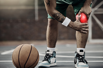 Image showing Sports, injury in basketball and knee pain or athlete man while on an outdoors court holding his hurt leg during training or exercise for hobby. Closeup of male hands on glowing red body part