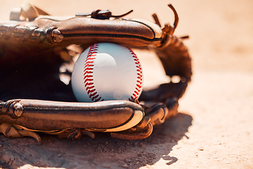 Image showing Baseball, sport and exercise with a ball and glove on a base plate on a pitch or field outdoor for a competitive game or match. Fitness, sports and skill with equipment on the ground for training