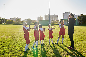 Image showing Football girl team stretching with coach on a sports field for fitness, training and exercise. Soccer player club or athlete group and trainer teaching children or kids muscle wellness grass outdoor