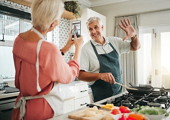 Image showing Phone, cooking and photograph with a senior couple in the kitchen recording a video while preparing breakfast food. Mobile, love and fun with an elderly man and woman pensioner in the house together