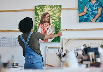 Image showing Woman artist, painter and hanging canvas on wall for exhibition to display in studio, art gallery or workshop. Female, lady and creative showing and holding artistic piece and painting in workspace.