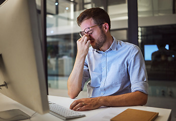 Image showing Night business, stress and tired man sitting at his computer desk with headache, depression and burnout from work pressure. Stressed, mental health and depressed male working late in his office