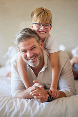 Image showing Family, love and children with a father and son lying on bed together in a bedroom of their home. Face, happy and smile with a portrait of a man and his boy child in their house to relax on a morning