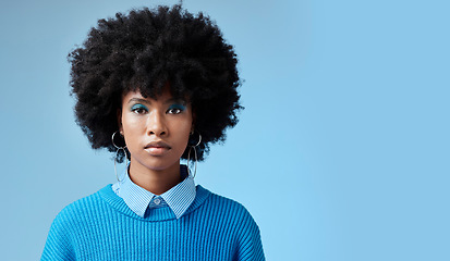 Image showing Portrait of black woman, fashion afro and serious face with an expression of focus on blue background studio mockup. Trendy earing accessory, stylish cool clothing and blue cosmetic eyeshadow makeup