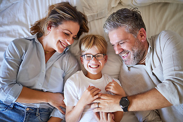 Image showing Family, tickling and child lying on bed with his happy mom and dad laughing and having fun in their bedroom at home. Portrait of boy kid with a man and woman parents to relax in their Australia house