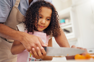 Image showing Father with kid helping her in the kitchen and cooking food together. Dad helps girl chop vegetable or fruit for healthy meal for lunch. Child development, teaching and learning how to cook at home