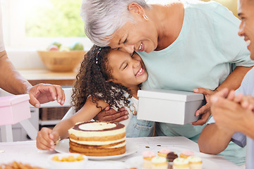 Image showing Hug, happy and gift giving of a grandmother and girl with birthday cake at a party celebration. Happiness of people at a children event to celebrate with food, family and friends smile at a home
