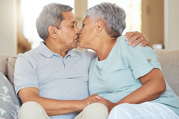 Image showing Senior couple, kiss and love at home while sitting on sofa in lounge to bond, relax and enjoy free time during retirement. Old man and woman sharing romantic and sweet moment in their Mexico house