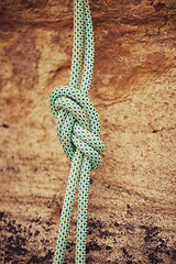 Image showing Safety, security and mountain climbing rope knot for helping on outdoor or outside strong rock challenge fall risk danger. Fitness, exercise and training equipment gear for workout or wall adventure