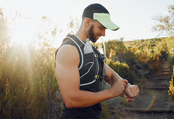 Image showing Man, nature and hiking with time on smartwatch in sunshine for run, hike or race. Runner, fitness and trail for health, wellness and workout on sport adventure during summer with tech, gps or clock