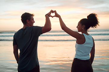Image showing Beach, couple and heart hand at sunset with happy people bonding together on Mexico holiday break. Care, love and trust in interracial romantic relationship with people enjoying ocean sky at dusk.