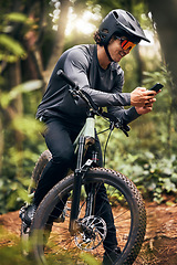 Image showing Fitness, phone and forest cyclist in nature and sustainability New Zealand woods with gps location, health data and tracking app. Smile, happy and training sports biker with helmet and 5g mobile tech