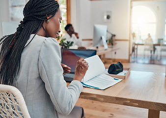 Image showing Paperwork, office and black business woman reading corporate company documents at her desk in the workplace. Professional, young and african leader or manager working on a management strategy report.