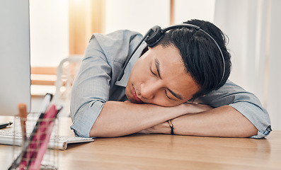 Image showing Man, burnout and tired at work in call center, communication or customer support job in Shanghai. Asian, worker and crm sleeping in office at customer service, consulting or telemarketing in China