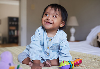 Image showing Down Syndrome, smile and happy baby relax on bed having fun, play with toys and enjoy happiness at home. Intellectual disability, mentally disabled and child development for young toddler in bedroom