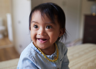 Image showing Baby, girl and cute with a down syndrome little child on a bed in the bedroom of her home alone. Children, kids and face with a sweet female kid looking innocent, pure and carefree in her house