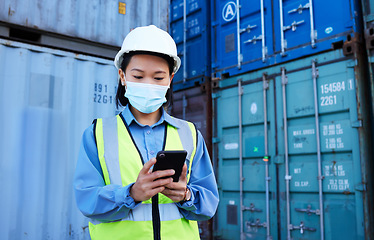 Image showing Covid, supply chain logistics and phone with a woman shipping worker managing an online order on a container dock. Stock, freight and cargo with a female courier at work on a smartphone for export
