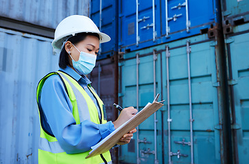 Image showing Covid, shipping logistics and employee writing during inspection at a container warehouse. Asian industrial engineer woman with ecommerce notes and planning delivery of cargo with a face mask