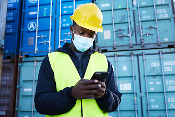 Image showing Mask, covid and logistics and black man with phone or shipping worker check a online order on a container port. Stock, freight and cargo with a male courier at work in export and delivery industry