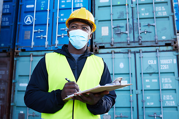 Image showing Covid, documents and supply chain logistics with a black man shipping expert at work on a commercial container dock. Clipboard, freight and cargo with a courier in a mask working in export industry