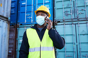 Image showing Logistics worker, container and covid, phone call in shipping port in face mask. Cargo area, smartphone and black man talking on call. Communication, protection and employee safety at freight company