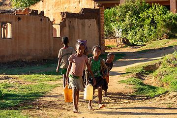 Image showing Morning ritual in Lakanga village as Malagasy girls fetch water for cooking. Andringitra mountain, Madagascar