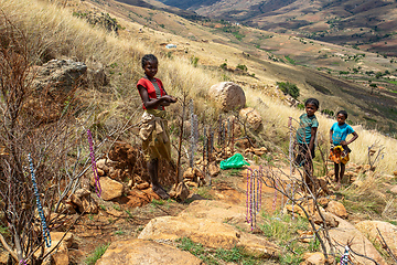 Image showing Local young girl and boy selling souvenirs standing in mountainous landscape. Andringitra, Madagascar