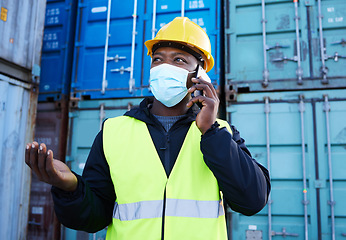 Image showing Covid, logistics and black man on phone call while working at a container warehouse. African industrial manager talking about shipping, delivery and cargo on a mobile with a face mask at storage site