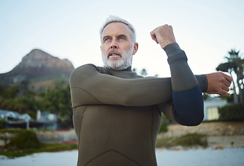 Image showing Fitness, surf and stretching with a sports man getting ready for a workout, exercise or training outdoor at the beach. Health, wellness and performance with a mature male at the start of his routine