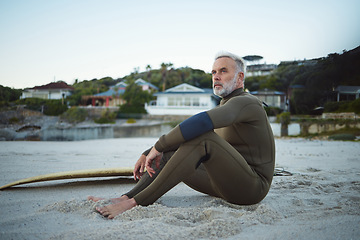 Image showing Thinking, relax and surfer man on the beach for rest, peace and freedom while on tropical holiday. Thoughtful, retirement and senior man sitting on sand in nature by the ocean during surf training.