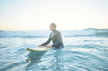 Image showing Swimming, beach and old man in water surfing enjoying a summer holiday vacation his retirement in Los Angeles, USA. Fitness, healthy and senior person waiting for ocean waves on his surfboard at sea