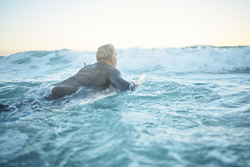 Image showing Surf, sea and water sports with a mature man surfing, swimming and body boarding in the ocean while enjoying surfer trip for summer travel. Male athlete on his surfboard in the ocean for Bali holiday