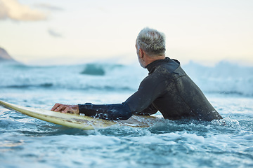 Image showing Water, board and surfer surfing the waves at the beach on holiday in Thailand during sunrise in summer. Man in the ocean with a surfboard on a travel vacation for nature adventure by the sea